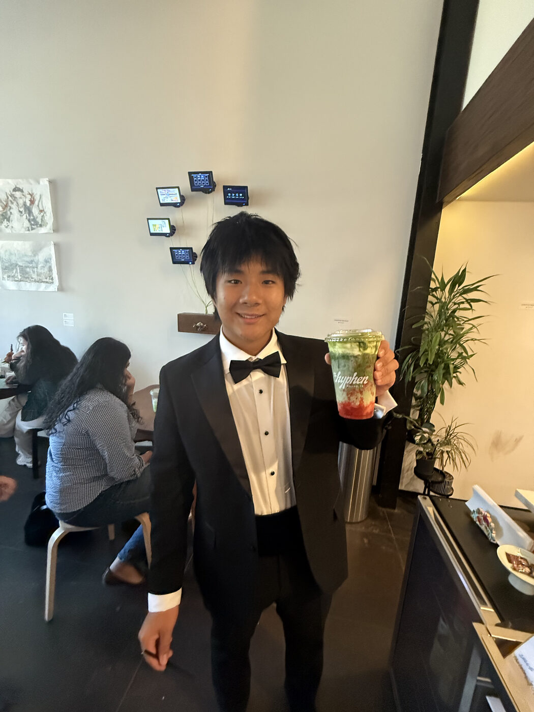 Daniel in a tuxedo holding a matcha