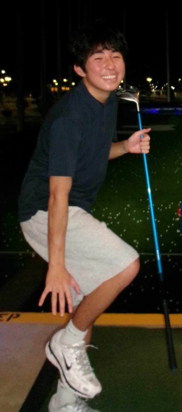 Nolan posing at a driving range
